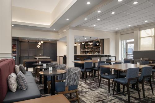 a restaurant with tables and chairs and a bar at Hilton Garden Inn Indianapolis/Carmel in Carmel