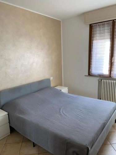 a bedroom with a bed with a blue blanket at Regina House Cattolica in Cattolica