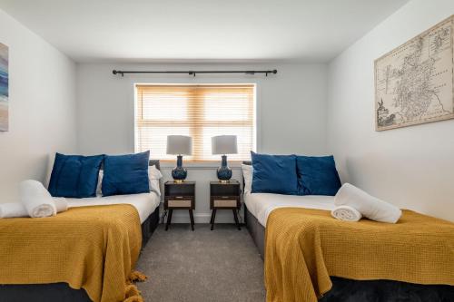 two beds in a room with blue and white at Rosemount - Kilrenny in Kilrenny