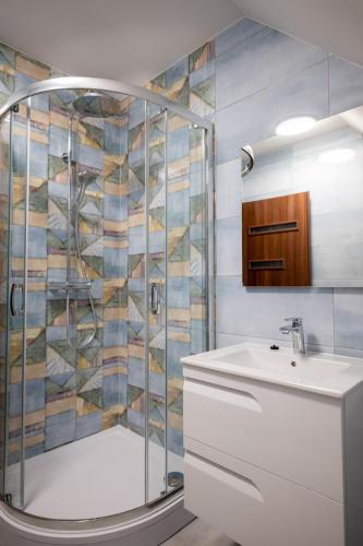 a bathroom with a shower and a sink at Pihenőkert Vendégház in Békésszentandrás