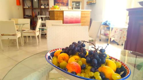 un cesto di frutta seduto su un tavolo di vetro di Maison Degas-Dimora di Charme a Napoli