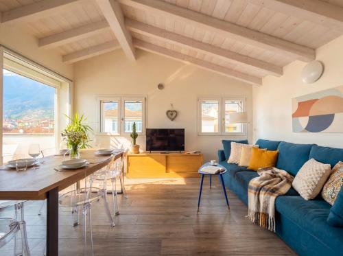 a living room with a blue couch and a table at PENTHOUSE ISEO LAKE VIEW - Free Wi-Fi and Private Parking Included in Sale Marasino