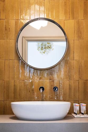 a bathroom with a white sink and a mirror at Dattilo Wine Relais in Torre Melissa