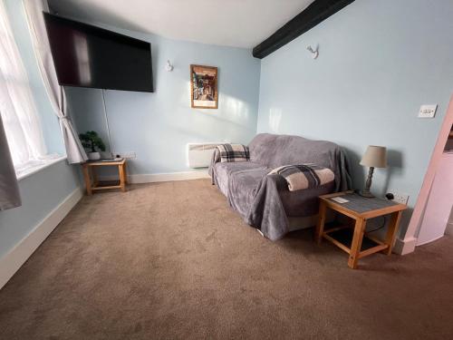 a living room with a bed and a flat screen tv at Cartway Apartment in Bridgnorth