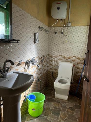 a bathroom with a white toilet and a sink at Soshing Homestay in Ravangla