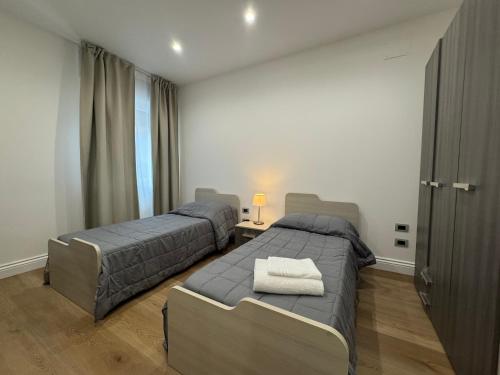 a bedroom with two beds and a table with a lamp at Maison Trentasette in Potenza