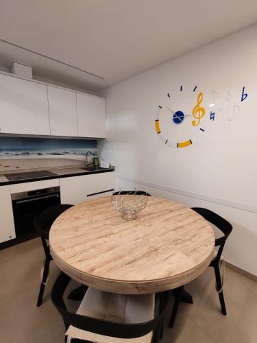 a kitchen with a wooden table and a clock on the wall at I Limoni in Sanremo