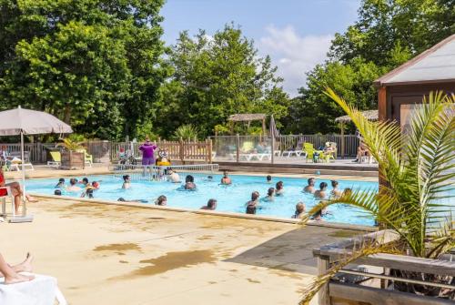 a group of people swimming in a swimming pool at Camping Le Soleil des Landes in Lit-et-Mixe