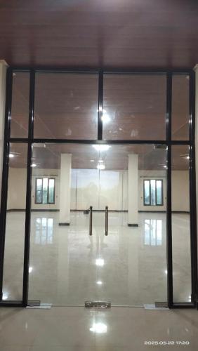 ein leerer Raum mit Glastüren in einem Gebäude in der Unterkunft Aco Borneo Hotel in Malinau