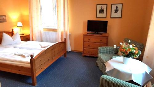 a hotel room with a bed and a television at Pension Am Holzgraben in Lübbenau