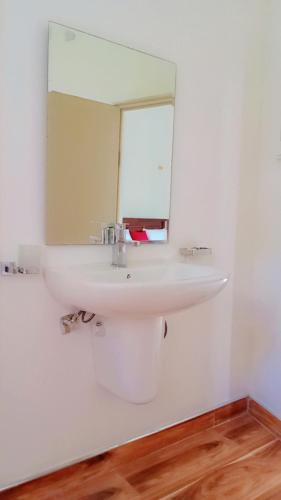 a bathroom with a white sink and a mirror at Horton Grand Boralanda in Haputale