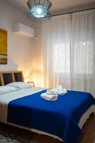a bedroom with a blue bed with towels on it at The Hidden Cellar by Heavens Hall in Alexandroupoli