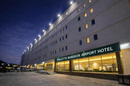 a large building with a hotel at night at Palette Bangkok Airport Hotel in Bangkok