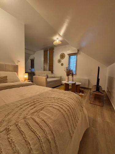 a bedroom with a large bed and a couch at Résidences Eska in Bobigny