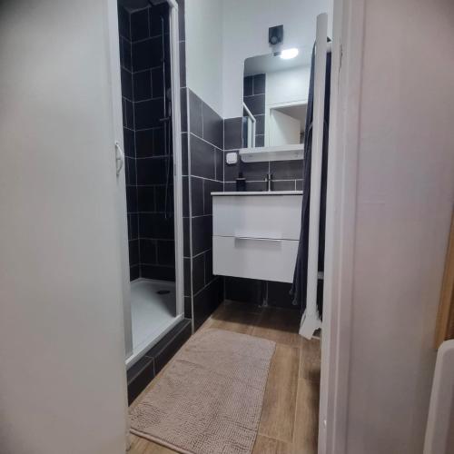a bathroom with a sink and a shower with a mirror at Résidences Eska in Bobigny