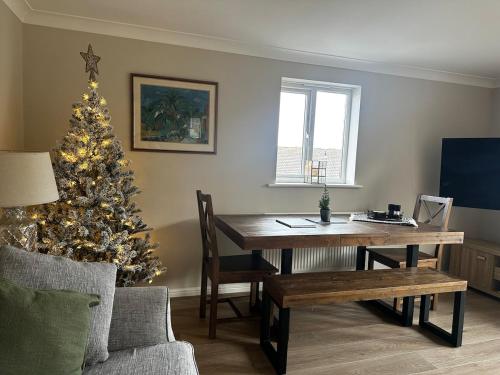 a living room with a table and a christmas tree at Castle View, Cosy Stay in Strood