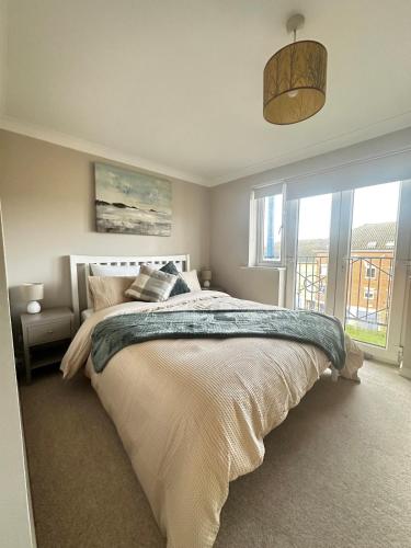 a bedroom with a large bed and a large window at Castle View, Cosy Stay in Strood