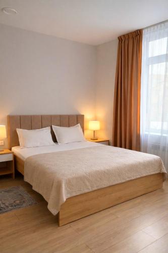 a bedroom with a large bed and a window at SAFIA Hotel in Pavlodar