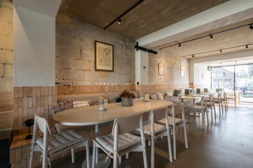 a restaurant with tables and chairs and a brick wall at K-Kanne in Kanne