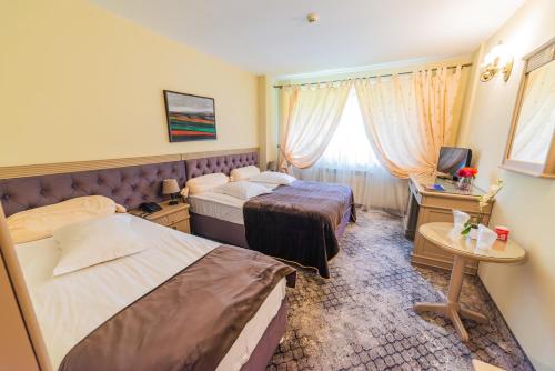 a hotel room with two beds and a television at Bucium Motel & SPA in Iaşi