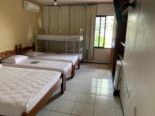 a room with three bunk beds and a window at Pousada Malu in Fortaleza