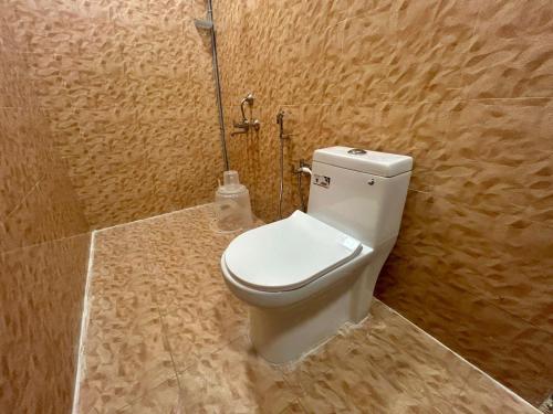 a bathroom with a white toilet in a room at Hotel unity Park in Pondicherry