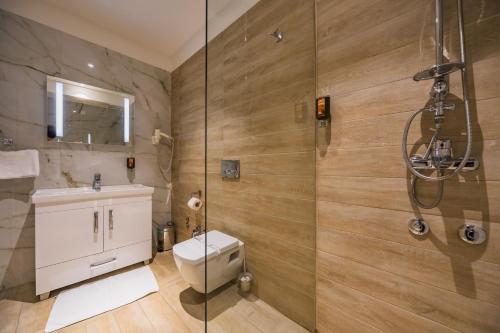 a bathroom with a shower and a toilet and a sink at Hotel Franca Tivat in Tivat
