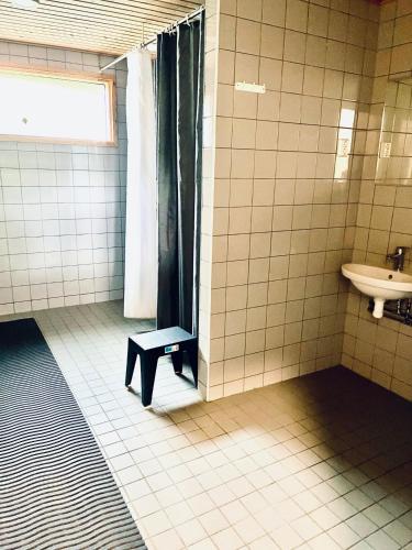 a bathroom with a sink and a shower and a bench at Vuohensaari, Rantatalo 5 in Salo