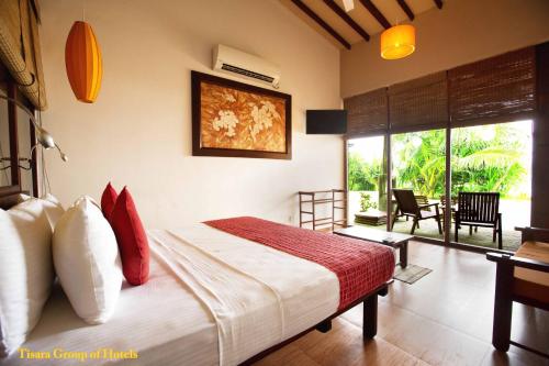 a bedroom with a bed with red and white pillows at The Beach Cabanas Retreat & Spa in Koggala