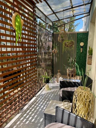a patio with a wooden fence and tables and chairs at Maya Apartment in Cluj-Napoca