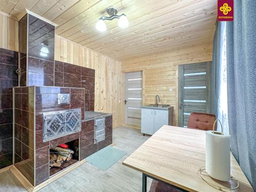 a kitchen with a fireplace and a table in a room at Трофейна хатина in Krivopolʼye