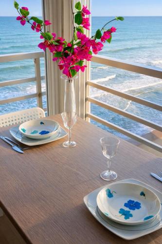 a table with plates and a vase with flowers on it at Un Rincon en el Mar in Bellreguart