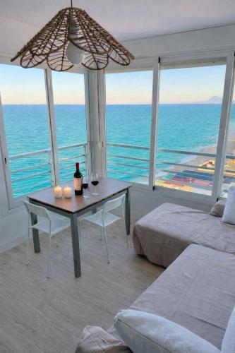 a bedroom with a table and a view of the ocean at Un Rincon en el Mar in Bellreguart