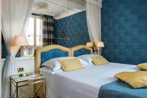 a bedroom with two beds with blue walls at Art Hotel Orologio in Bologna