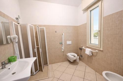 a bathroom with a toilet and a sink and a shower at Hotel Villa Tina Easy Stay B&B in Cesenatico