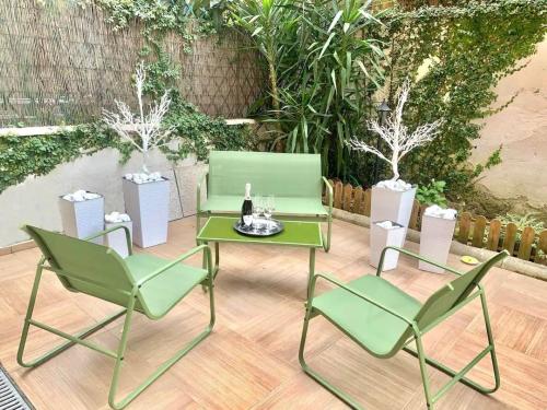 two green chairs and a table with a bottle of wine at Luxury Vatican Home - Private Garden in Rome