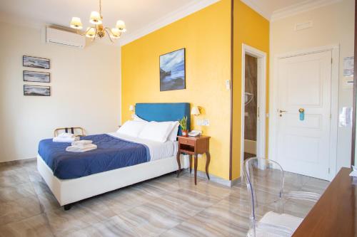 a bedroom with a bed with a blue and yellow wall at NeapolitanTrips Hotel in Naples