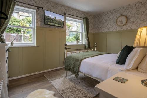 a bedroom with a bed and two windows at Boar Edge Cottage in Richmond