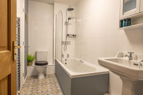 a bathroom with a sink and a toilet and a bath tub at Boar Edge Cottage in Richmond