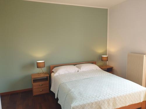 a bedroom with a bed with two night stands and two lamps at New N3-House by Anthea Homes in Casièr