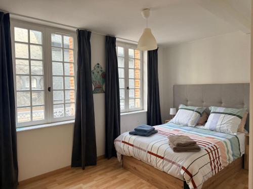 a bedroom with a bed and two windows at Le 8 Chaussée Honfleur in Honfleur