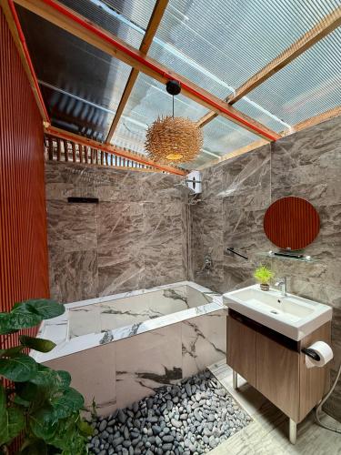 a bathroom with a bath tub and a sink at Thani's Little Cabin Rental - Native Room in Caibiran