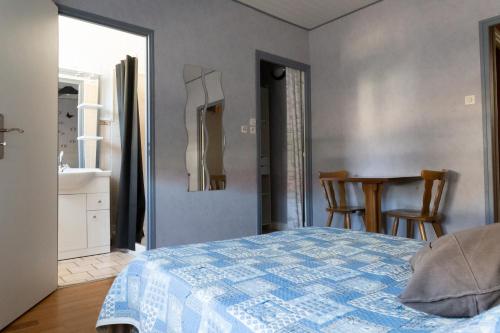 a bedroom with a bed and a table with chairs at chambres d'hotes Lagarde in Lagarde