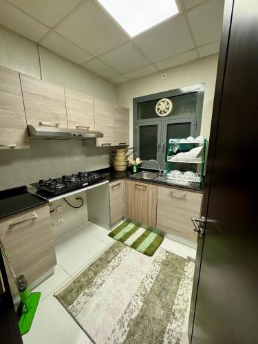 une cuisine avec un évier et une cuisinière dans l'établissement Farno Hostel, à Mascate
