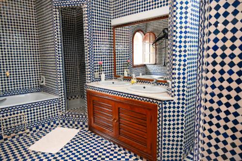 a bathroom with a sink and a mirror and a tub at Dar Maya Original Suite & Spa in Fez