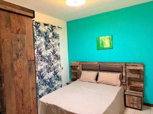 a bedroom with a bed with a blue wall at Sea Bliss Villa1 in Pereybere