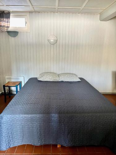 a bedroom with a blue bed with two pillows at Vuohensaari, Rantatalo 6 in Salo