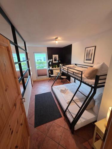 a room with two bunk beds and a living room at Kapitänshaus - Terrassenstube in Barth