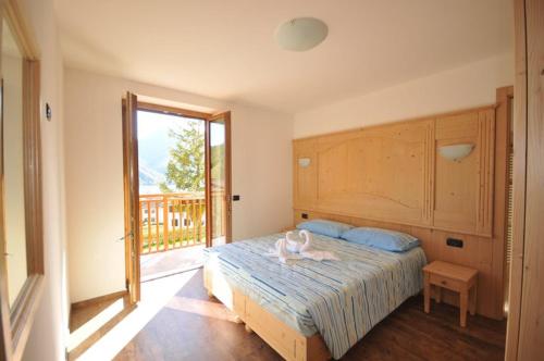a bedroom with a bed and a large window at B&B Ledro AFFITTACAMERE in Mezzolago