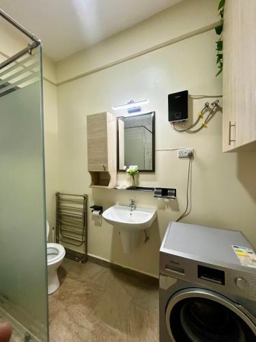 a bathroom with a sink and a washing machine at Ibis Stays in Naziba